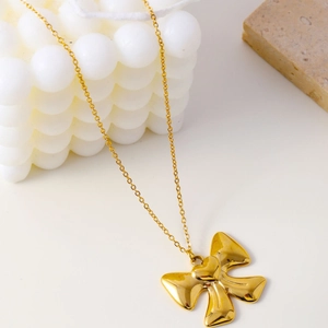 Collier nœud minimaliste en acier inoxydable doré avec pendentif cœur sur décor