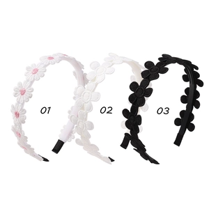 Detailed close-up of embroidered daisy headbands in pink, white, and black colors