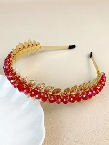 Detailed view of handmade gold leaf headband with red crystal beads and vintage metal design