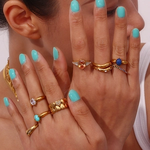 Detail of multi-style 18K gold plated rings and snake chain on model hand