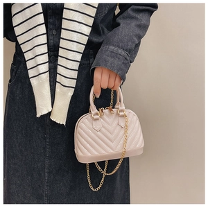 Detail of milk tea jelly shell bag with V-quilted texture and gold chain strap