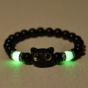 Detailed view of luminous cat head bracelet showing green glowing beads in the dark