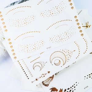 Golden temporary face tattoos with moon, butterfly and celestial dot patterns