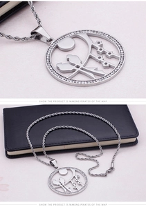 Detail of a bird nest pendant necklace with white zircons and a twisted chain