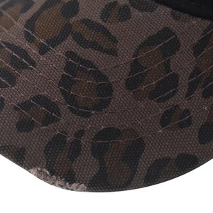 Vue détaillée de la casquette léopard avec bord usé et coutures foncées sur tissu en coton