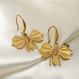 Elegant gold titanium steel insect earrings with pink oval gemstone on white silk background