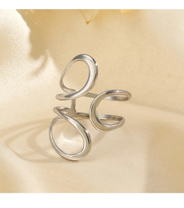 Detail of silver hollowed irregular ring on a beige satin background with soft lighting