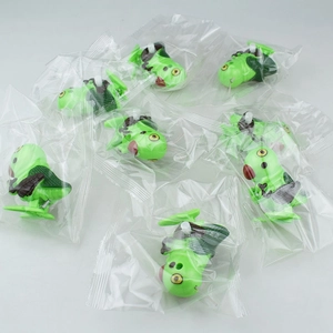 Close-up of green caterpillar wind-up toys in individual plastic packaging bags