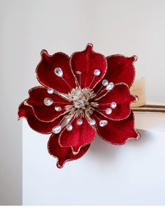 Detail of red velvet magnolia flower with gold glitter edges and sparkling rhinestones
