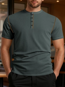 Detail of dark gray short sleeve polo shirt with contrast stitching and buttoned placket