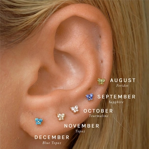 Detail of five butterfly stud earrings with colorful birthstones for August to December