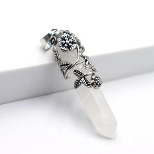 Vue macro d'un pendentif hexagonal en cristal blanc enveloppé de fleurs en argent