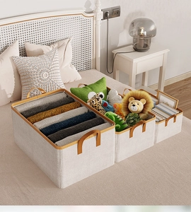 Three sizes of beige fabric storage bins with brown leather handles for home organization