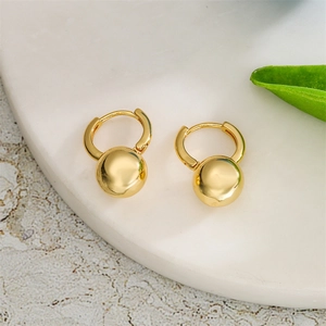 Dettaglio di orecchini a cerchio geometrici placcati oro 14K con ciondoli a perla liscia
