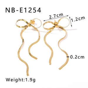 Detail view of gold bow earrings with measurements and snake chain tassel texture