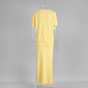Back view of yellow knit set with short sleeve top and long skirt on a mannequin