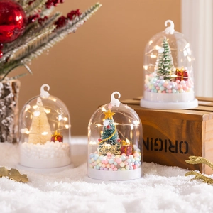 Close-up of glowing Christmas crystal ball with LED lights on a snowy background