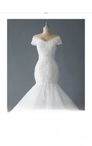 Détail de la robe de mariée sirène blanche à épaules dénudées avec broderie de dentelle