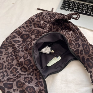 Detailed view of leopard print canvas bag interior showing large capacity and zipper pocket