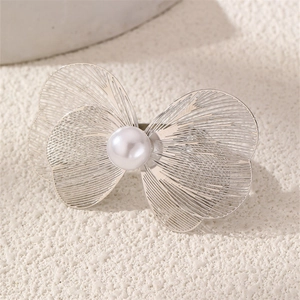 Macro shot of silver butterfly ring with filigree metalwork and a central white pearl
