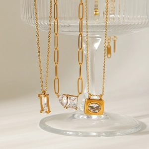 18K gold plated stainless steel necklaces with zircon pendants on ribbed glass stand