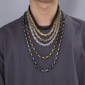 Detail of multi-color Byzantine chain necklaces in gold, silver, and black stainless steel