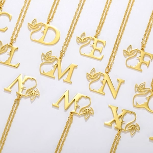 Golden stainless steel letter necklace with artistic silhouette and leaf pendant for women