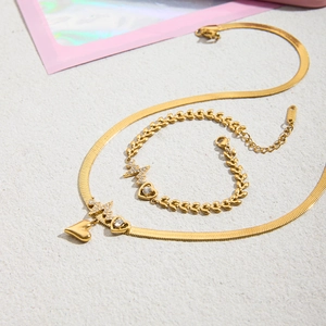 18K gold plated heart necklace and bracelet set with zircons on textured white background