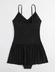 Detail of black eyelet swimdress featuring floral embroidery and adjustable straps