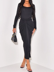 Detail of elegant black long-sleeve maxi dress with twist front knot design