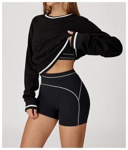 Detail of black long-sleeve sports sweatshirt and high-waist shorts with white contrast lines