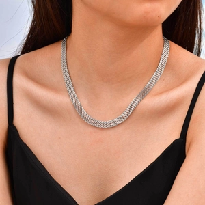 Detail of a 3mm to 8mm wide silver mesh chain necklace on a model's neck