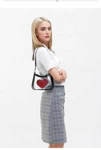 Detail view of transparent PVC crossbody bag with black trim and a red heart logo
