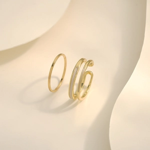Detailed close-up of gold minimalist multi-layer ring with white enamel inlay accents