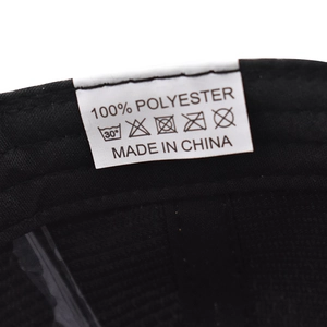 Detail view of internal white care label on black fabric showing 100% polyester material