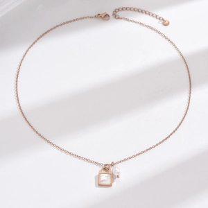 Rose gold necklace featuring a square lock pendant with white shell and irregular pearl