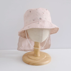 Detail of pink floral sun hat with red cherry embroidery and protective neck flap