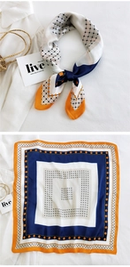 Detailed view of square silk scarf with geometric patterns in orange and navy blue