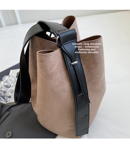 Detail of camel brown suede bucket bag with adjustable black leather shoulder strap