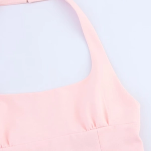 Detail of pink halter neck top featuring fine textured fabric and bow decoration