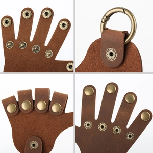 Detail view of brown cowhide leather hand-shaped keychain with vintage brass snap buttons