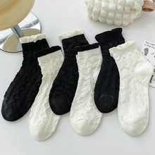 Detail of candy-colored low cut socks with ruffled edges and assorted knit patterns