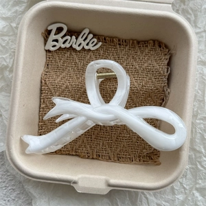 Detailed macro view of white marble textured acetate hair claw clip with golden spring