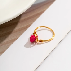 Detailed wire-wrapped golden ring featuring a vibrant fuchsia opal stone focal point