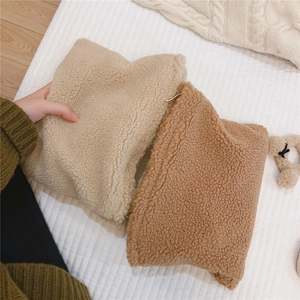 Detail showing the soft lamb wool texture of the winter handbag in beige and camel colors