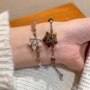 Detail of bohemian woven bracelets with star-shaped crystals and tiger eye stones