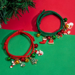 Detail of Christmas braided bracelets with enamel charms and small bells in red and green