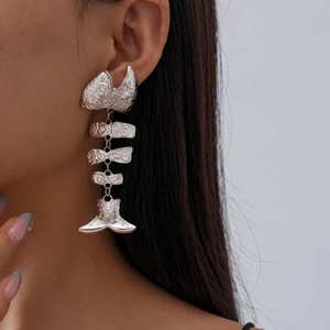 Detailed view of silver fishbone chain earrings with a metallic textured fringe design