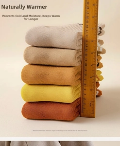 Close-up of five pairs of thick ribbed wool socks stacked 20cm high in warm autumn colors