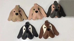 Detailed top view of five colorful leather beagle dog keychains with contrast stitching